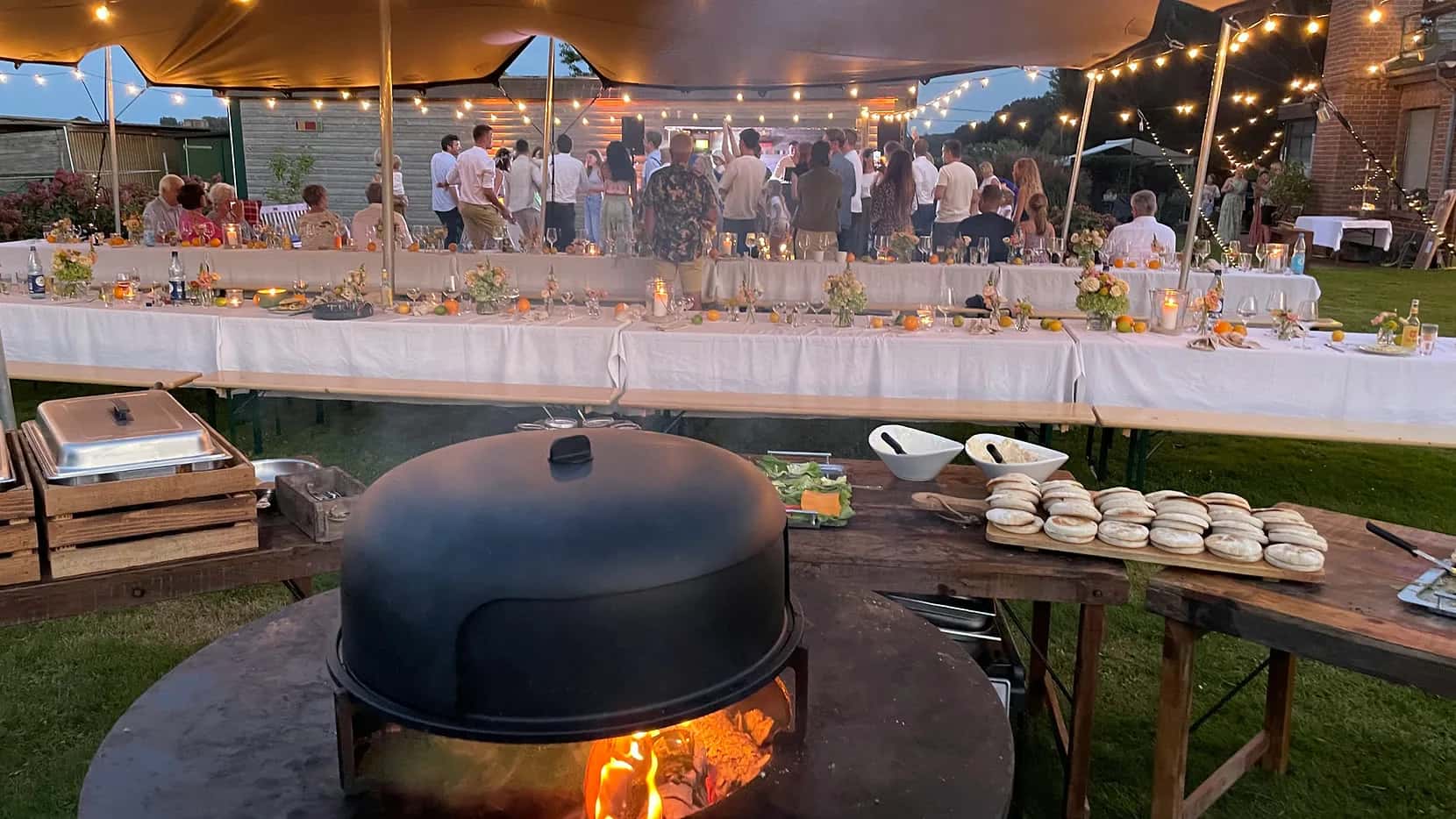 Sommerabend mit gedeckter Tafel, Lichtern und Eventcatering im Außenbereich